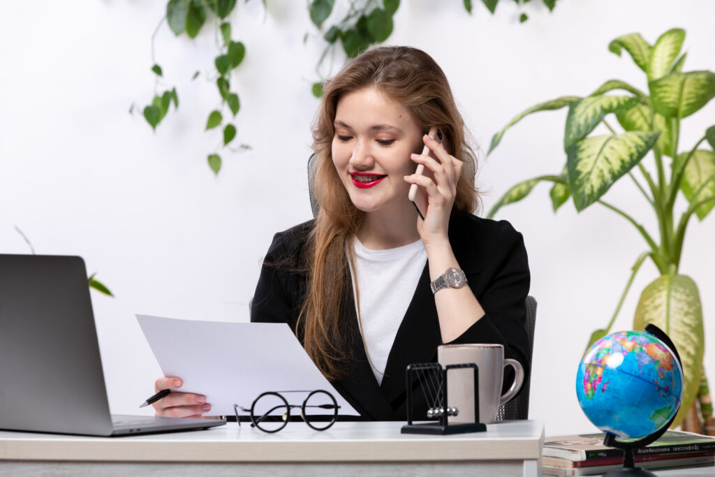 front view young beautiful lady white shirt black jacket using her laptop front table smiling talking phone working with documents